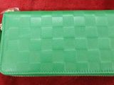 une photo d'un sac à main vert posé sur un tapis rouge