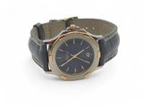 une photo d'une montre-bracelet au cadran bleu, montée sur un bracelet en cuir noir