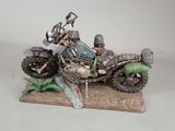 figurine of a man riding a motorcycle with a skeleton on the back