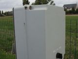 a white box that is on the side of a fence