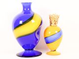 two vases sitting next to each other on a white surface