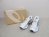 La paire de chaussures de course blanches et noires se trouve à côté d'une boîte