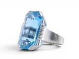 a close up of a ring with a large blue topaz stone