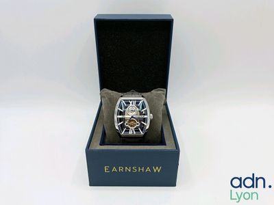 une montre dans un coffret posé sur une surface blanche