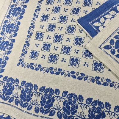 a close up of a table cloth with blue flowers on it
