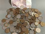 une pile de pièces posée sur une table à côté d'un billet de banque