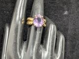 paire de bagues ornées de pierres d'améthorate, exposées sur la main d'un mannequin
