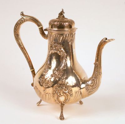 an antique silver plated teapot with ornate decoration on a stand