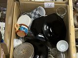 Des cartons remplis d'objets divers sont posés par terre dans une pièce