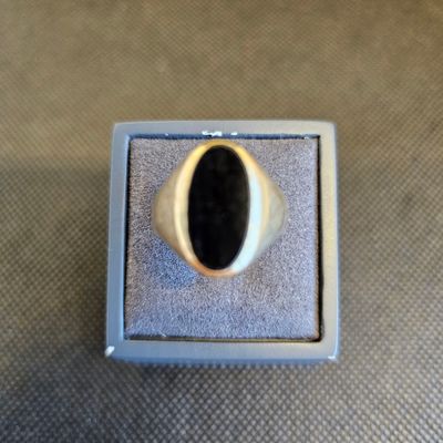 un gros plan d'une bague en argent sertie d'une pierre noire