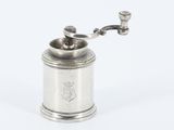 un moulin à café plaqué argent muni d'une poignée, sur fond blanc