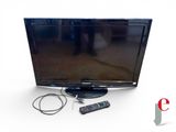 une télévision à écran plat posée sur une table à côté d'une télécommande