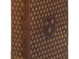 un vieux livre à la couverture brune posé sur une surface blanche