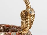 a close up of a snake on top of a basket on a table