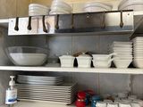 beaucoup d'assiettes et de bols sur les étagères de la cuisine