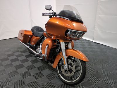 une moto orange garée sur un sol à carreaux noirs et blancs