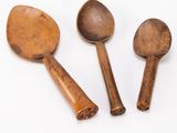 three wooden spoons and a wooden spoon on a white surface