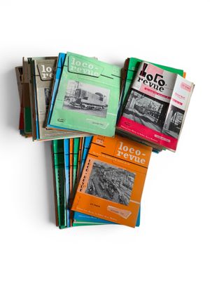 several books are stacked on top of each other on a white surface