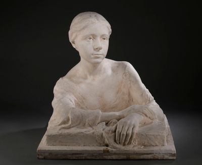 statue d'une femme assise sur un bloc de pierre, les mains posées sur les genoux