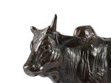 a statue of a cow that is standing on a white surface