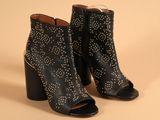 a pair of black leather ankle boots with silver studding