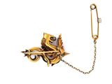an image of a gold broochle with a chain attached to it