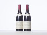 two bottles of wine sitting on top of a white table