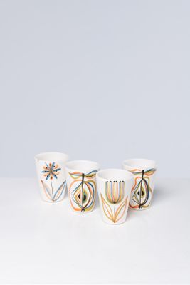 three white bowls with colorful designs on them sitting on a table