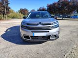 the front end of a silver citrole parked in a parking lot