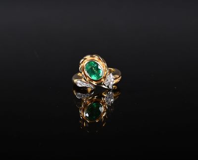 une bague en émeraude et diamant sur une surface noire