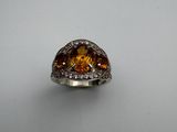 an image of a ring with a large citrine stone surrounded by diamonds