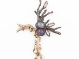 a close up of a metal cross with a bird on it