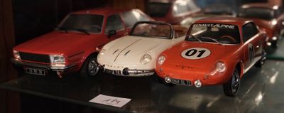 Plusieurs petites voitures sont exposées dans une vitrine.