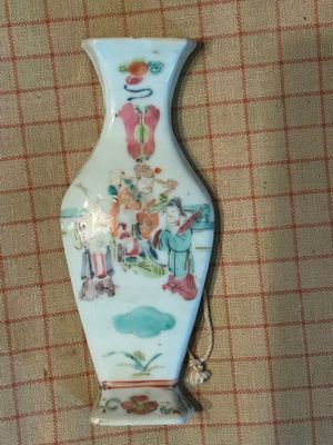 un vase orné d'une image représentant des personnes, posé sur une table