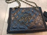 a black chanel bag with a chain hanging from it