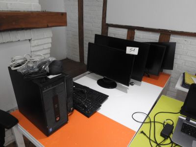 a desk with three computers and a laptop on it