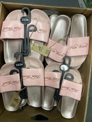 six paires de chaussons roses dans une boîte en carton