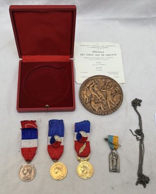 une boîte rouge sur laquelle sont posées une médaille, une médaille et une médaille