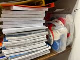 a stack of papers and tape on a shelf