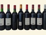 six bottles of red wine are lined up in a row