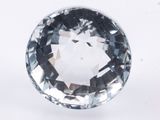 a close up of a faceted blue diamond on a white surface