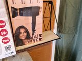 un sèche-cheveux posé sur une étagère à côté d'une boîte de sèche-cheveux