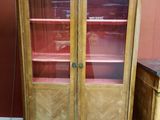 un meuble en bois avec des portes en verre dans une pièce