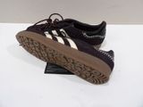 the shoe is black and white with a brown sole