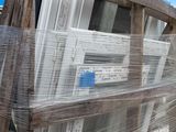 a lot of windows on a pallet in a warehouse