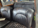 two black seats in the back of an old car