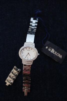 a close up of a watch on a black surface with a tag