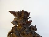 a wooden statue of a woman with a bird on her head