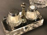 two salt and pepper shakers on a tray on a table