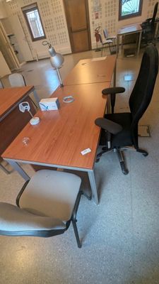 une photo d'un bureau vide avec un bureau et des chaises